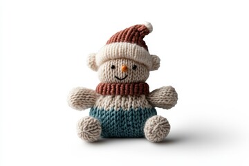A charming knitted snowman wearing a red hat and blue pants sits alone on a plain background. The image invokes a sense of warmth and sweet playfulness.