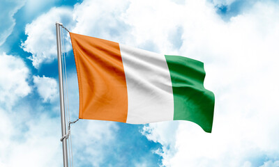 Cote d’Ivoire flag waving on sky background. 3D Rendering