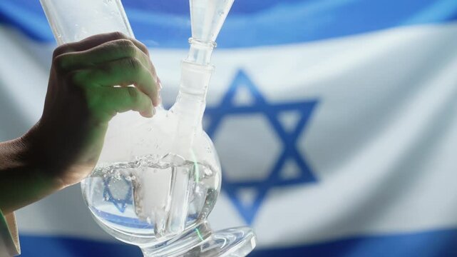 Woman smoking medical marijuana, glass water bong on israeli flag background. Cannabis tobacco, Shisha in Israel