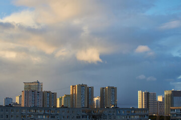 Fototapeta premium Cityscape with Towering Clouds and Evening Light