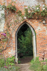 Fototapeta premium Archway in an old brick garden wall, Suffolk England 