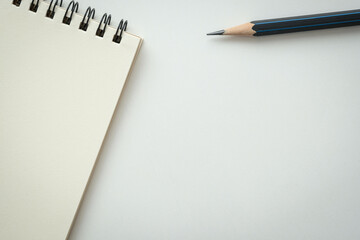 Open blank spiral notebook with black pencil on white background. Empty Space for your text.
