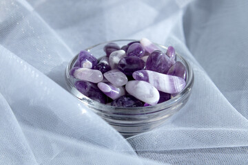 Set of various amethyst natural mineral stones and gemstones on white background partial focused