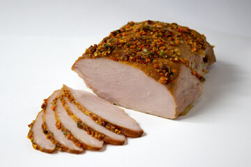 Sliced chicken breast with bright spices, baked meat, closeup, isolated on white background