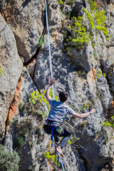 A tightrope walker walks along a cable stretched over a canyon.