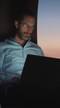 A dedicated professional works late on their laptop, showcasing creativity in a modern workspace
