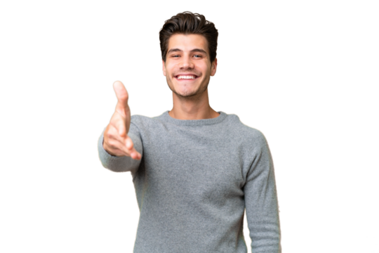 Young handsome caucasian man over isolated background shaking hands for closing a good deal