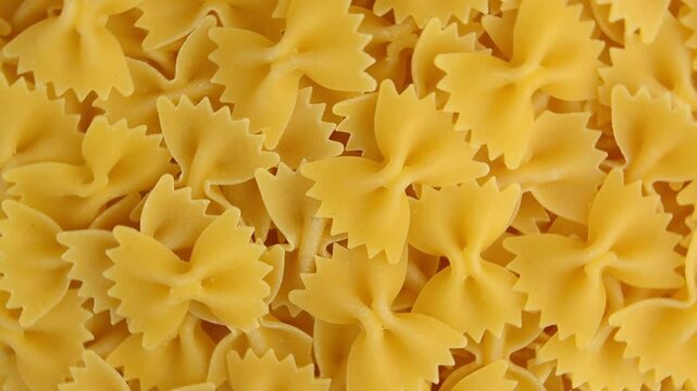 Raw farfalle pasta, rotating. Pasta in the form of butterflies or bows. View from above.