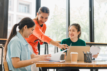 Collaborative women working together in modern office space, sharing ideas and documents while enjoying coffee. Their expressions reflect enthusiasm and teamwork