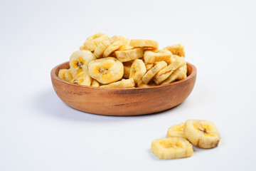 A bowl of banana chips sits on a white background