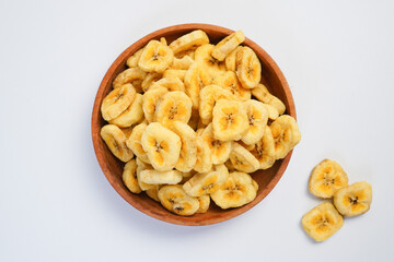 A bowl of banana chips is on a white background