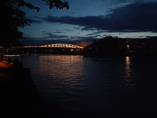 Pont sombre reflété dans le canal en soirée