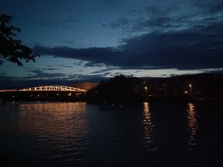 Pont sombre reflété dans le canal en soirée