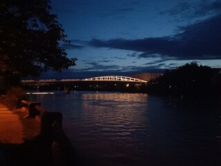 Pont sombre reflété dans le canal en soirée