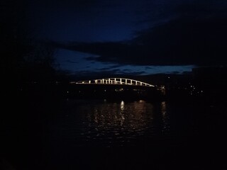 Pont sombre reflété dans le canal en soirée