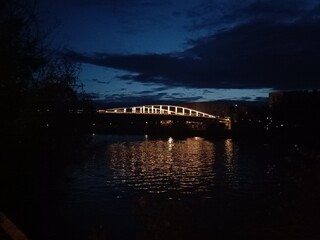 Pont sombre reflété dans le canal en soirée
