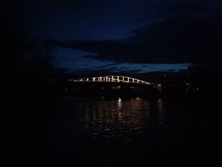 Pont sombre reflété dans le canal en soirée