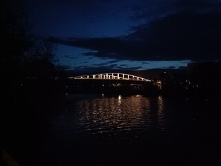 Pont sombre reflété dans le canal en soirée