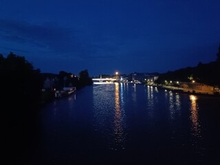 Pont sombre reflété dans le canal en soirée