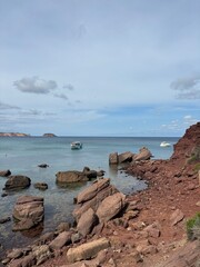 rocky red sand coast of the sea