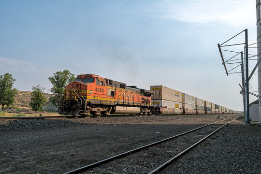 Lamona, Washington, USA - August 11,2024: BNSF locomotive 4360 pushes a freight train past the grain elevator