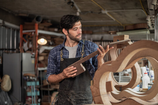 Luthier is working on the neck of a classical guitar