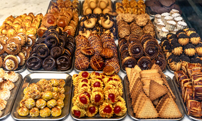 Confectionery, pastry shop or bakery window display with assorted freshly baked sweets, pastries, biscuits and cookies.