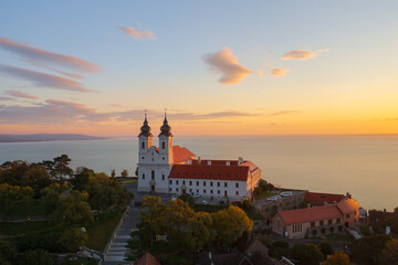 Fototapeta premium Tihany, Hungary - Aerial skyline view about the famous Benedictine Monastery of Tihany (Tihany Abbey) with beautiful colourful sky and clouds at sunrise.