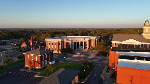 Aerial view of a drone approaching the Garrard County Judicial Center and Courthouse in Lancaster, Kentucky, with light morning traffic sparsely passing along Stanford Street in front of the building.