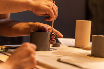 Hands Crafting Ceramic Mug in Artisan Workshop Setting