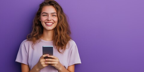 young smiling woman using mobile phone against purple background