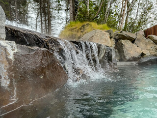 Obraz premium Akureyri, Iceland - August 9, 2024: A waterfall at a thermal pool along the shores in Akureyri, Iceland 