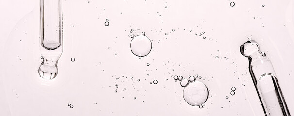 Two pipettes and a skin serum texture. Liquid body care product. Closeup. Copy space