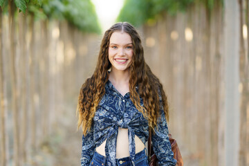 Fototapeta premium A Joyful Young Woman Smiling Brightly in a Lush and Beautiful Natural Setting Around Her