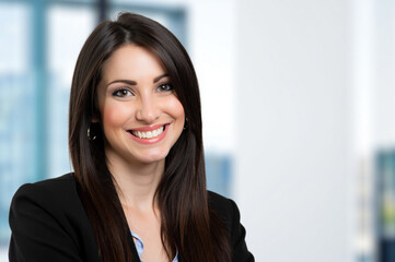 Fototapeta premium Happy businesswoman smiling in modern office