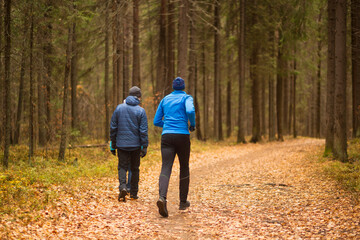 Fototapeta premium A man runs in an autumn park. Doing sports outside.