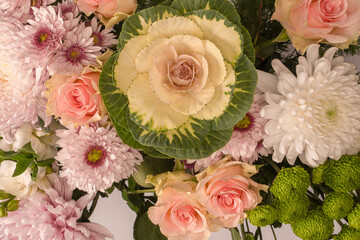 Bouquet of flowers with pink roses, brassica flower, chrysanthemum and freesia flower in a vase.