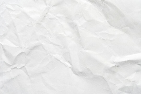 Crumpled white paper texture with natural creases and subtle shadows for backgrounds and design projects.