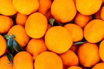 orange mandarin background of fresh juicy tangerines close up, vegan friut conception of citrus