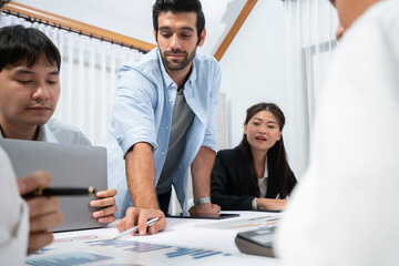 Analyst team utilizing BI Fintech to analyze financial data at table in meeting room. Businesspeople analyzing BI dashboard power on paper for business insight and strategic marketing planning.Prudent