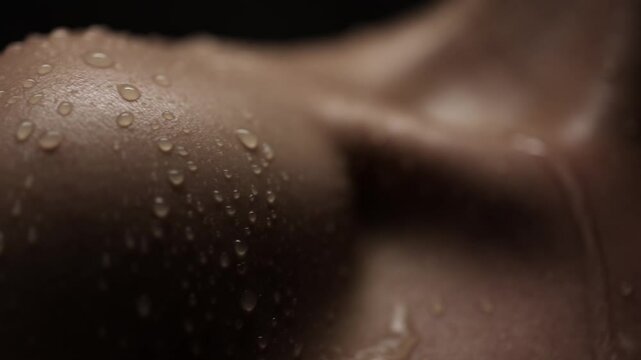 Close-up shot of an attractive woman's collarbone area, with water droplets glistening on her skin. This image conveys a sense of freshness and well-being, perfect for beauty and skincare themes.