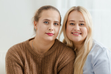 Portrait of two fair-haired plump women on a light background