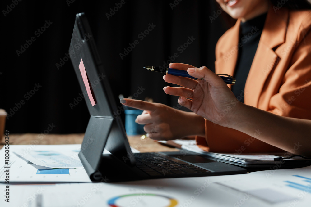 Wall mural two businesswomen are analyzing financial data on a digital tablet, pointing at the screen with a pe