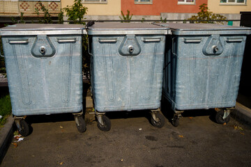 Three metal trash containers on the street, ecology concept and environmental protection