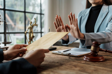 Lawyer refusing money from client in brown envelope, rejecting illegal act at lawyer's desk