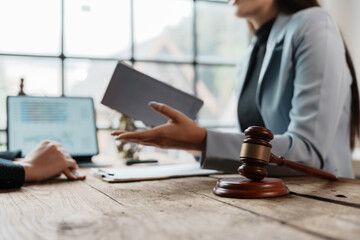 Lawyer is gesturing with her hand while explaining a lawsuit to a client during a consultation in the office