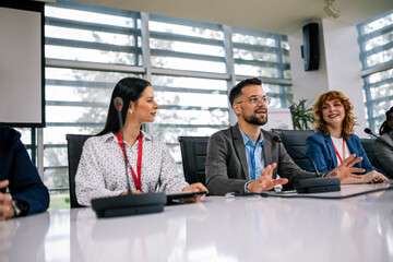 Man CEO talking on the microphone on meeting with his colleagues about business plan, future collaboration.