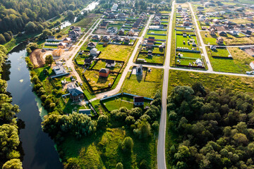 Cottage village under construction by the river, aerial view