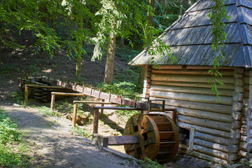 old wooden water mill, in the forest a wooden mill with a wheel, a beautiful retro mill