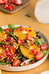 Vegan salad with citrus fruits, lettuce leaves and pomegranate. Christmas salad. 